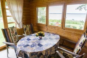 ein Esszimmer mit einem Tisch, Stühlen und Fenstern in der Unterkunft Ferienhaus Seensucht in Göhren-Lebbin