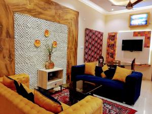 a living room with two couches and a tv at PANCHHI'S NEST Villa in Amritsar