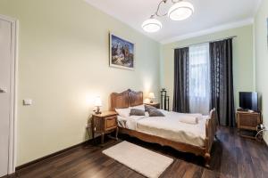 een slaapkamer met een bed en een televisie. bij Modern Chaikovskogo Apartment in Lviv