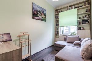een woonkamer met een bank en een boekenplank bij Modern Chaikovskogo Apartment in Lviv