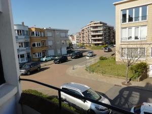 una vista de una calle con coches aparcados en un aparcamiento en LEHOUCK kamers ontbijt en Koksijde
