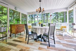a dining room with a table and chairs at Waterfront Great Pond Cottage with Hot Tub and Deck! in Aurora