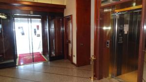 un couloir avec deux ascenseurs et deux portes dans un bâtiment dans l'établissement Le Gronde, à Cava Manara