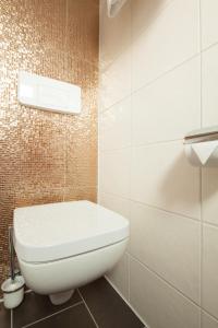 a white toilet in a bathroom with brown tiles at Hotel Elba am Kurfürstendamm - Design Chambers in Berlin