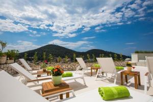a patio with chairs and tables and a mountain at Villa Boro 3 in Dubrovnik