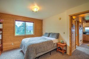 Schlafzimmer mit einem Bett und einem Fenster in der Unterkunft Luxe Alpine Cabin with Wraparound Deck and Mtn Views! in Alpine