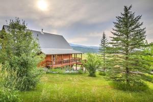 una baita di tronchi in mezzo a un campo alberato di Luxe Alpine Cabin with Wraparound Deck and Mtn Views! ad Alpine