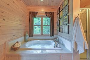 a bath tub in a wooden bathroom with a window at Dream Catcher Luxe Cabin with Large Deck and Mtn View in Sapphire +17 photos