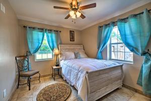 una camera da letto con un letto con tende blu e un ventilatore a soffitto di Oklahoma City Home with Yard - 5 Mi to Downtown! a Oklahoma City