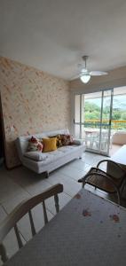 - un salon avec un canapé et une grande fenêtre dans l'établissement Apartamento - Jd São Lourenço - Bertioga - Praia da Riviera, à Bertioga