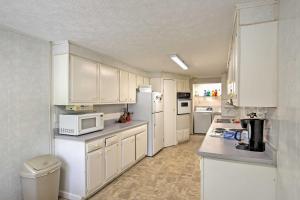 a kitchen with white cabinets and white appliances at Jasonville Cabin - Walk to Shakamak State Park! in Jasonville