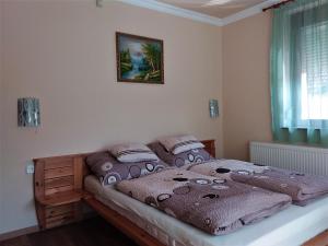 ein Schlafzimmer mit einem Bett in einem Zimmer in der Unterkunft Nefelejcs Fagyizó és Apartmanház in Kistolmács