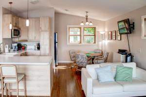 a living room with a white couch and a kitchen at Fish on Rice Lake Waterfront Brainerd Cabin in Brainerd