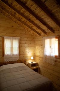 a bedroom with a bed and two windows at Farma Sotira in Leskovik