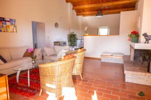 a living room with a couch and a table and chairs at Ca' le cerque, villa surrounded by the Marche nature in Fossombrone
