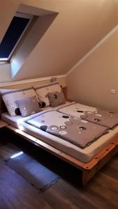 Bett in einem Zimmer mit in der Unterkunft Nefelejcs Fagyizó és Apartmanház in Kistolmács