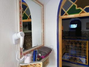 a bathroom with a mirror and a hair dryer at Hotel Abi khancha in Chefchaouen