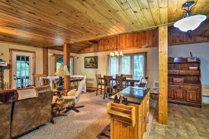 a living room with wooden ceilings and a dining room at Robbinsville Cabin with Deck 3 Mi to Fontana Lake! in Robbinsville