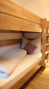 ein Etagenbett aus Holz mit zwei Kissen darauf in der Unterkunft Ferienhaus Raich in Vandans