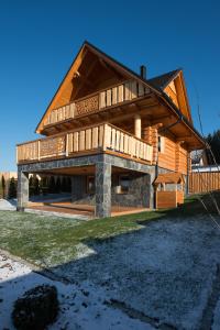 a large wooden house with a gambrel roof at Beskid Wood Houses in Jasnowice