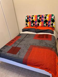 ミラノにあるBicocca Flat Fのカラフルな掛け布団が敷かれたベッド