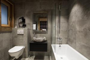 ein Badezimmer mit einer Badewanne, einem WC und einem Waschbecken in der Unterkunft Le Chalet Nativ in Morzine