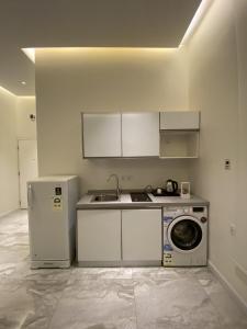 a kitchen with a sink and a washing machine at Sadan Furnished Apartments in Riyadh