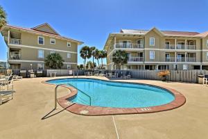 a swimming pool in front of a apartment complex at Emerald Hideaway Renovated Condo in Navarre Beach in Navarre