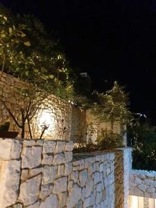 a stone wall with trees on top of it at night at Viva B&B in Anavyssos