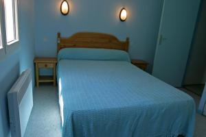 1 dormitorio azul con 1 cama con edredón azul en Arbizonloc, en Guchen