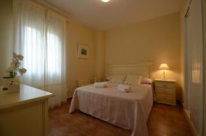 a bedroom with a bed and a dresser and a window at Apartamentos Solmares in Isla Canela