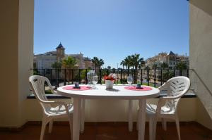 a white table and chairs on a balcony with a view at Apartamentos Solmares in Isla Canela