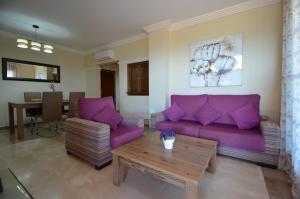 a living room with purple couches and a table at Apartamentos Solmares in Isla Canela