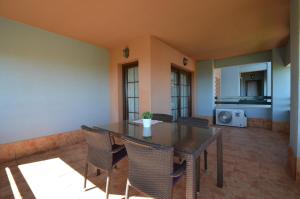 a dining room with a table and chairs and a microwave at Apartamentos Solmares in Isla Canela