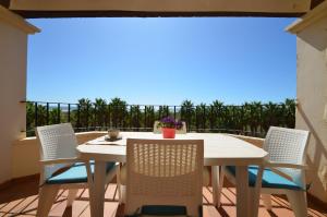 a white table and chairs on a balcony with a view at Apartamentos Solmares in Isla Canela