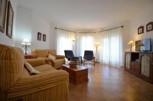 a living room with a couch and a tv at Apartamentos Solmares in Isla Canela
