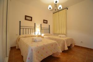 a bedroom with two beds and a chandelier at Apartamentos Solmares in Isla Canela