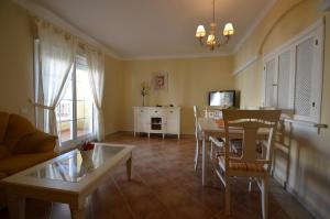 a living room with a table and a dining room at Apartamentos Solmares in Isla Canela