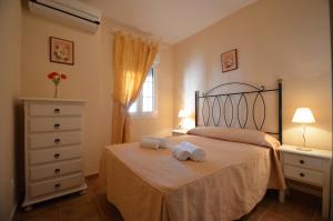 a bedroom with a bed with two towels on it at Apartamentos Solmares in Isla Canela
