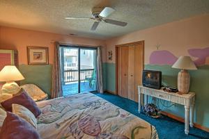 a bedroom with a bed and a television and a balcony at Kitty Hawk Townhome at Sea Dunes - Walk to Beach! in Kitty Hawk +30 photos