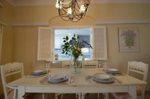 a dining room table with plates and a vase of flowers at Apartamentos Solmares in Isla Canela