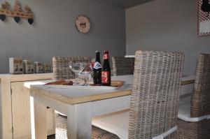 een eettafel met wijnflessen en glazen bij Gite du vieux pommier in Herbeumont