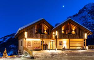a home in the mountains at night at Chalets 4 Sorus & Apartments La Villetta in Colfosco