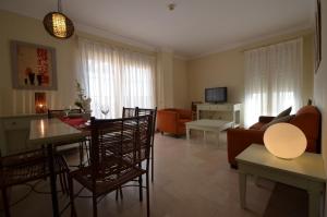 a living room with a couch and a table and chairs at Apartamentos Solmares in Isla Canela