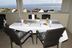 a table with plates of food on top of a balcony at Apartments "sea view" Miki & Ivana in Bol