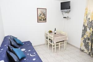 a small room with a table and a bed and a tv at Apartments "sea view" Miki & Ivana in Bol
