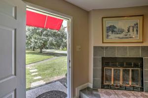 a living room with a fireplace and a red window at Baton Rouge Townhome with Pool Access - 7 Mi to LSU! in Baton Rouge