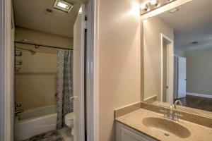 a bathroom with a sink and a toilet and a mirror at Baton Rouge Townhome with Pool Access - 7 Mi to LSU! in Baton Rouge +16 photos