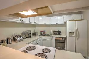 a kitchen with white cabinets and a white refrigerator at Baton Rouge Townhome with Pool Access - 7 Mi to LSU! in Baton Rouge