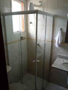 a shower with a glass door in a bathroom at Hotel Sol do Pernambuco in Guarujá